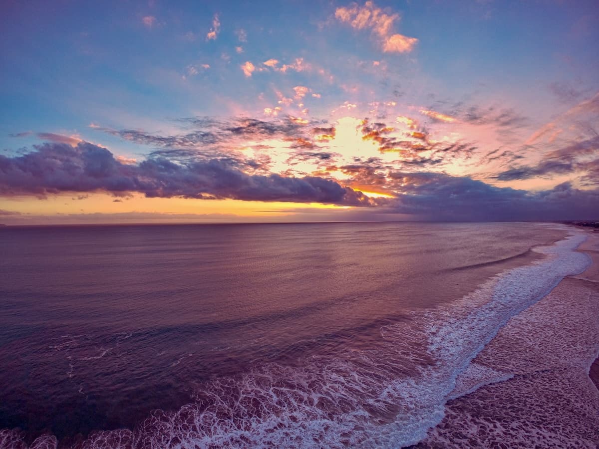 Bali Seminyak โ beach club loungers facing the Indian Ocean at sunset